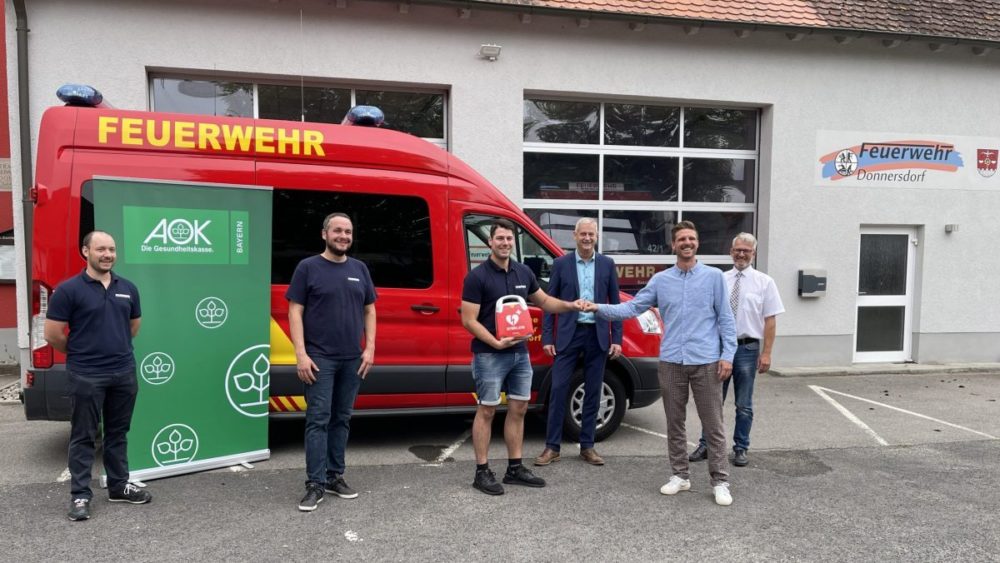 Die Übergabe des Defibrillators aus der Mainlike Aktion bei der Feuerwehr in Donnersdorf. Von links: Michael Solf (stv. Kommandant), Matthias Krüger (Kommandant), Jan Barthel (Jugendwart), AOK Direktor Frank Dünisch, Jakob Frank von SträtzFN Medizintechnik und der Donnersdorfer Bürgermeister Klaus Schenk. ©mainlike.de